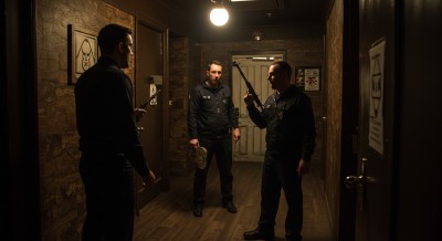 Security personnel inspecting a tense scene in a narrow corridor